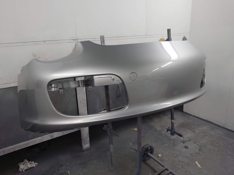 the front bumper of a silver porsche car is being worked on in cardiff accident repair centre