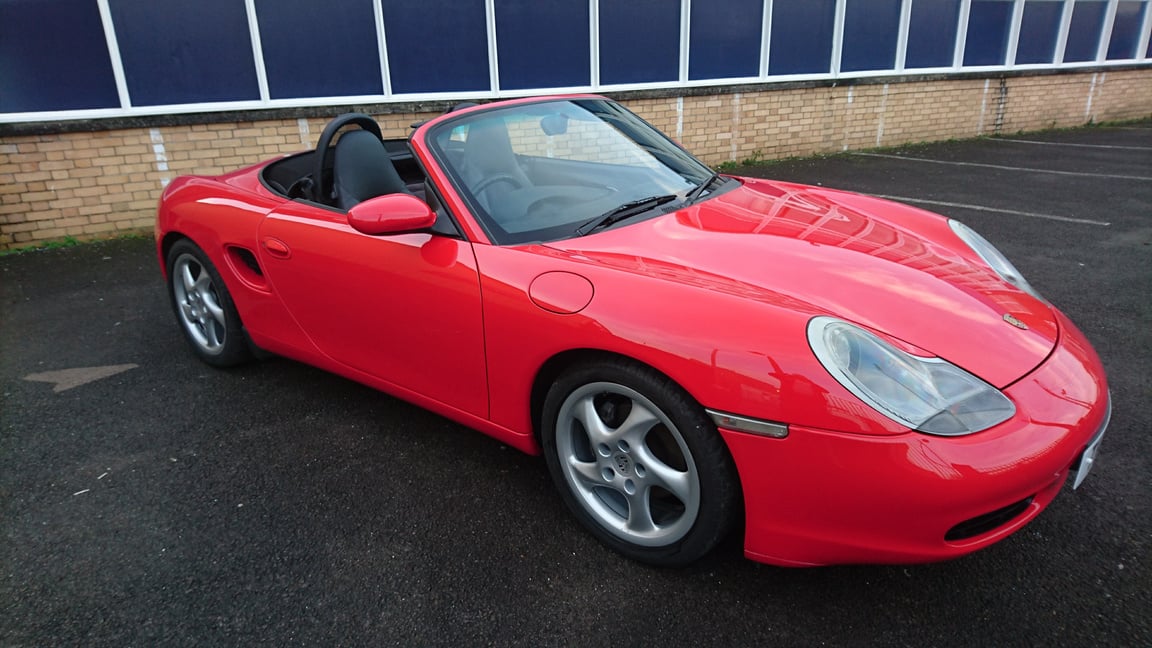 a red porsche sports car parked in front of a building in cardiff for car body repair  near me in south wales